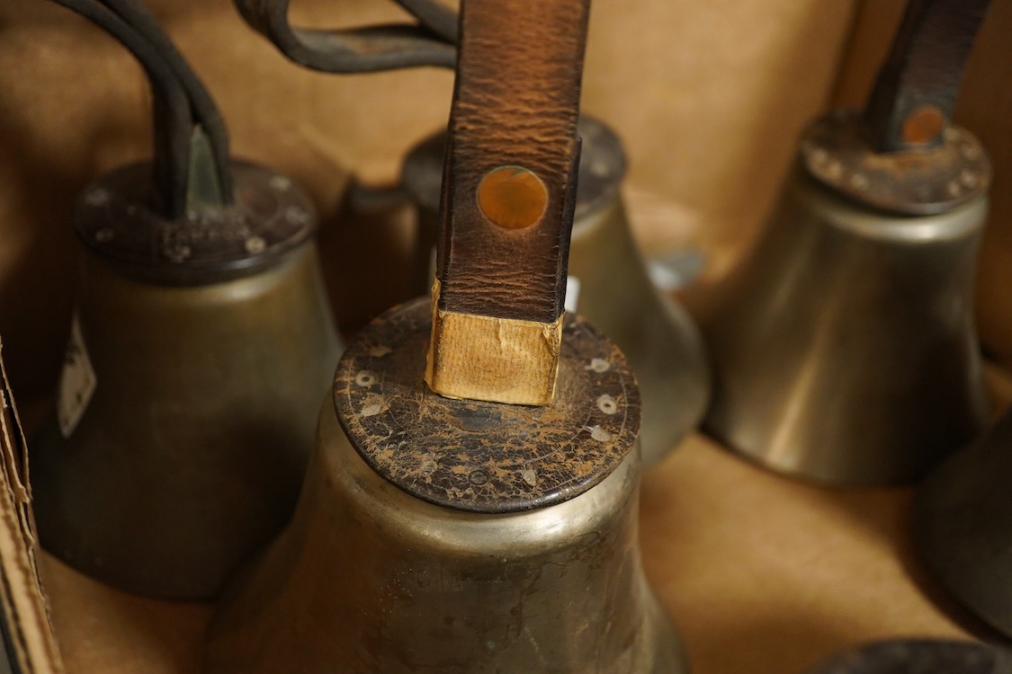 A set of twenty-two bronze handbells by Mears, London, with leather grips, together with two books from the Jasper Snowden Change Ringing Series, largest diameter 16cm